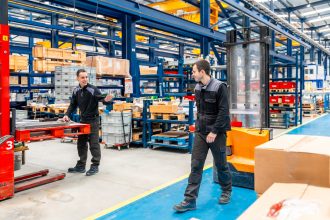 Team of warehouse using automated equipment and handling workers in a modern logistic factory