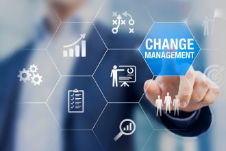 A man is holding a blue button that says changing management.