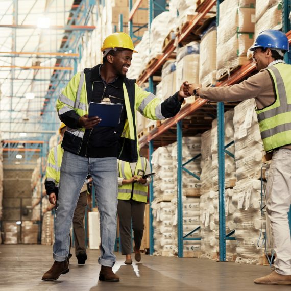 men-fist-bump-teamwork-warehouse-logistics-clipboard-greeting-by-shelf-respect-inspection-people-happy-inventory-distribution-smile-supply-chain-industrial-plant